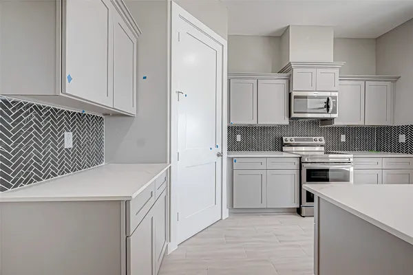 a kitchen with granite countertop white cabinets and white appliances