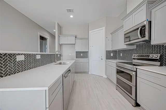 a kitchen with a sink stove and microwave
