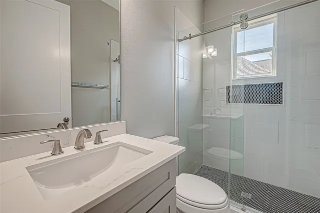 a bathroom with a sink toilet vanity and shower