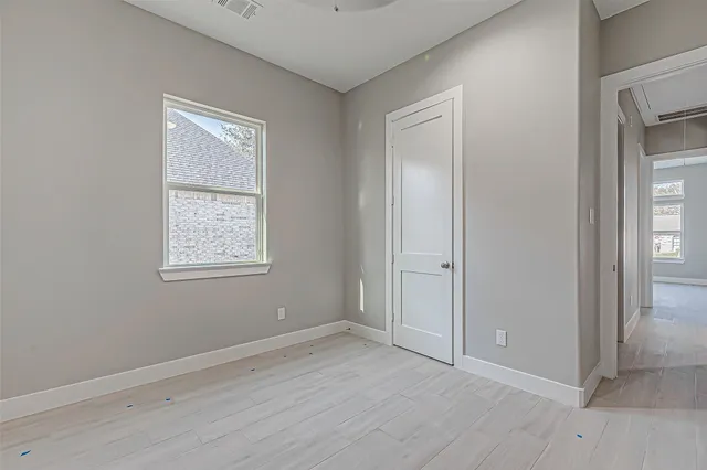 an empty room with windows and closet