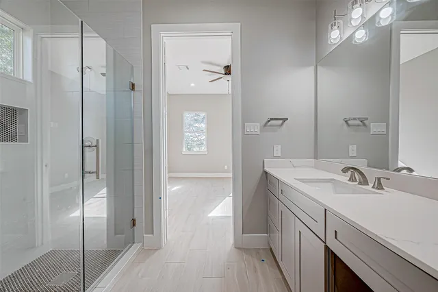 a spacious bathroom with a shower sink and mirror