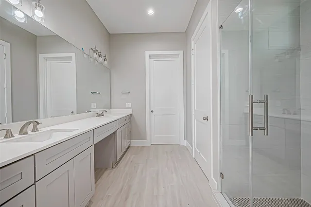 a spacious bathroom with a double vanity sink and mirror