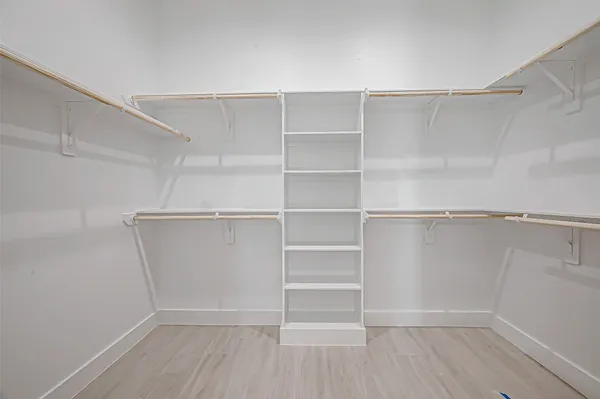 a view of walk in closet with empty racks
