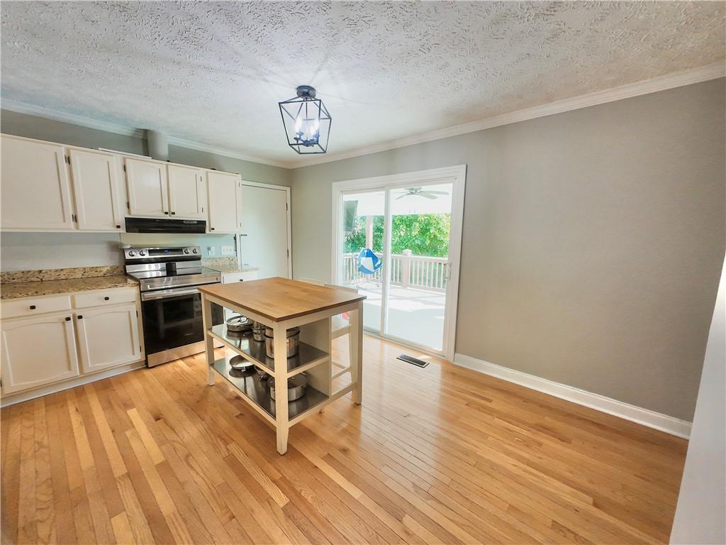 3905 Hunt Drive Gainesville, GA 30507 - Photo 6 of 16 a kitchen with stainless steel appliances granite countertop a stove top oven a sink dishwasher and a refrigerator with wooden floor