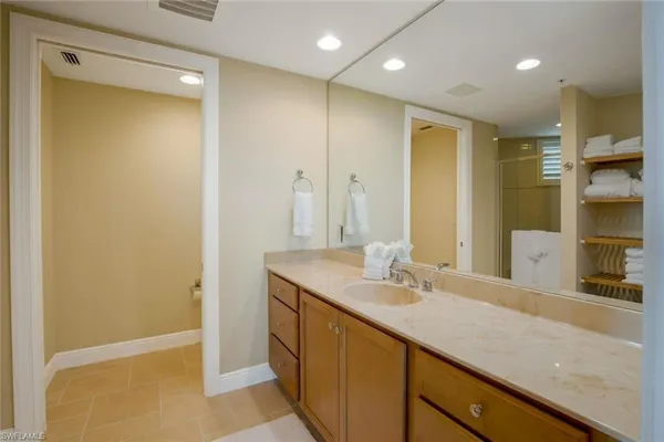 a bathroom with a granite countertop sink a mirror and a shower
