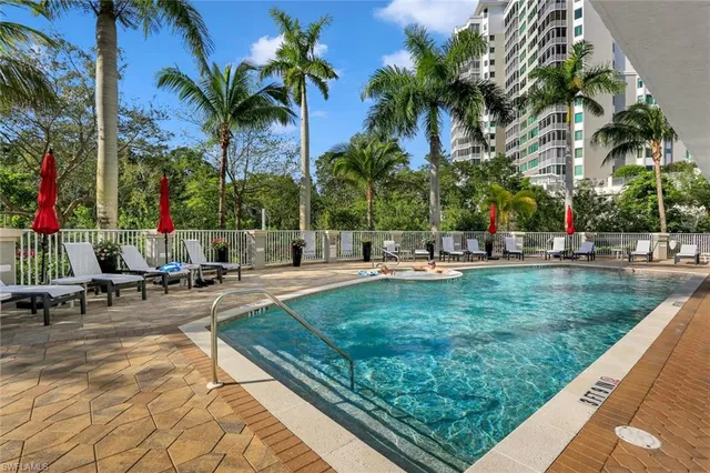 a row of palm trees sitting in a yard with swimming pool