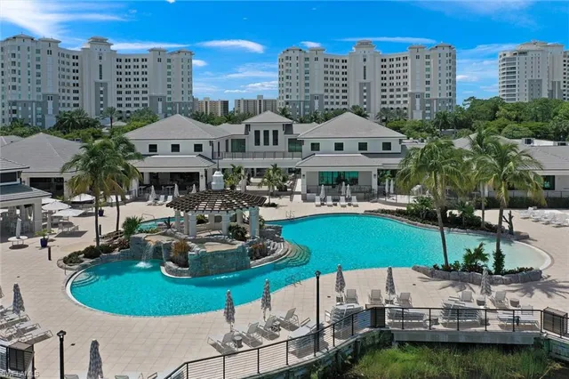 a front view of a building with a garden and trees