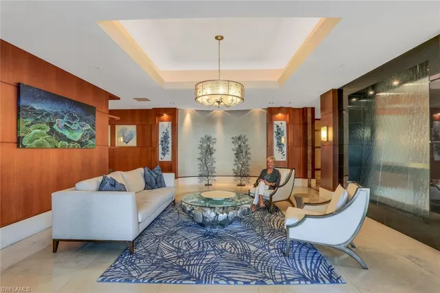 a living room with furniture and a chandelier