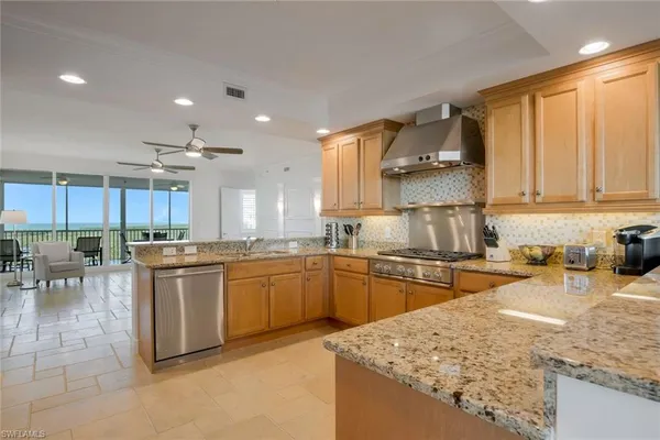 a kitchen with stainless steel appliances granite countertop sink stove top oven and cabinets