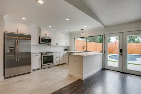 a kitchen with a refrigerator and a stove top oven