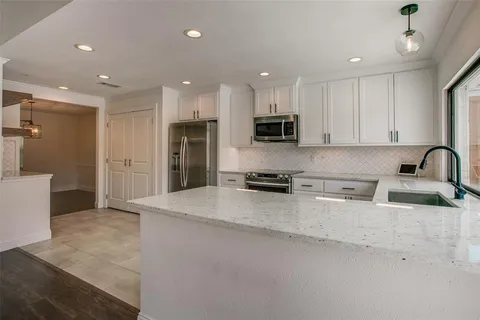 a kitchen with stainless steel appliances a refrigerator sink and microwave