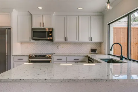 a kitchen with stainless steel appliances granite countertop a stove a sink and a microwave