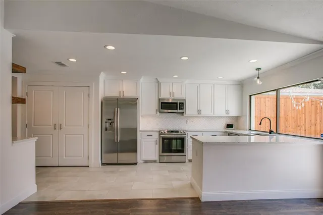 a view of kitchen with stainless steel appliances granite countertop a stove a sink and a refrigerator
