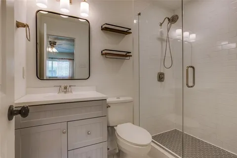 a bathroom with a toilet sink vanity and mirror