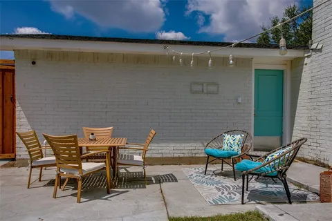 a backyard of a house with table and chairs