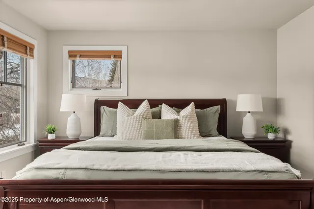 a bedroom with a bed and painting on the wall