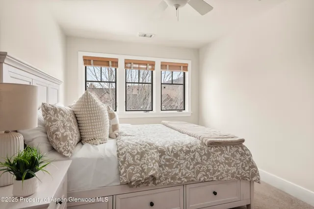 a bedroom with a large bed and a potted plant