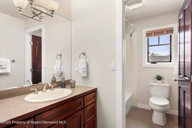 a bathroom with a sink vanity mirror and toilet