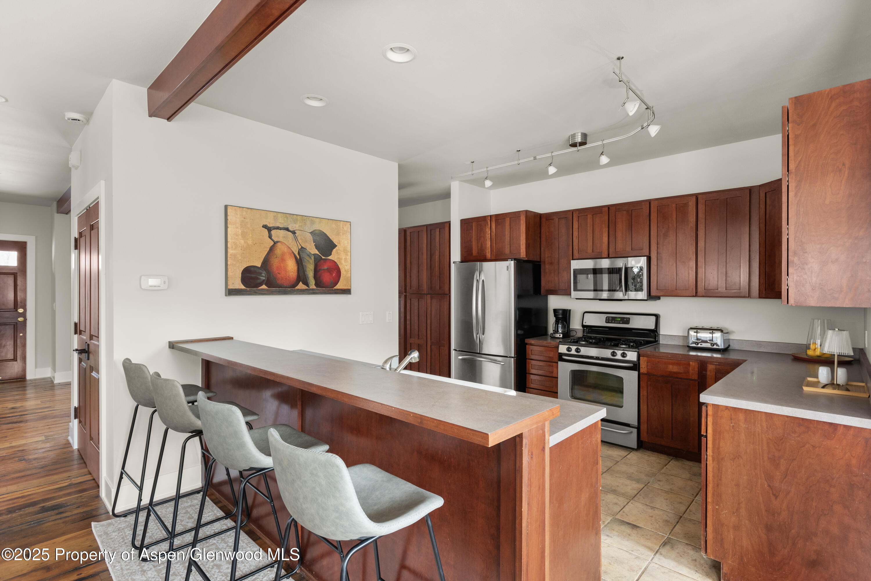 314 Sopris Circle Basalt, CO 81621 - Photo 5 of 36 a kitchen with stainless steel appliances a refrigerator a stove a sink a dining table and chairs with wooden floor