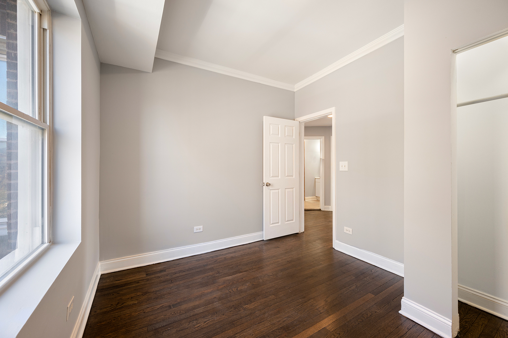 2437 East 74th Street, Unit 3W Chicago, IL 60649 - Photo 11 of 18 a view of an empty room with wooden floor and a window