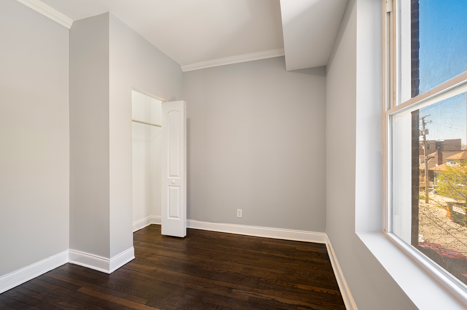 2437 East 74th Street, Unit 3W Chicago, IL 60649 - Photo 12 of 18 a view of an empty room with wooden floor and a window