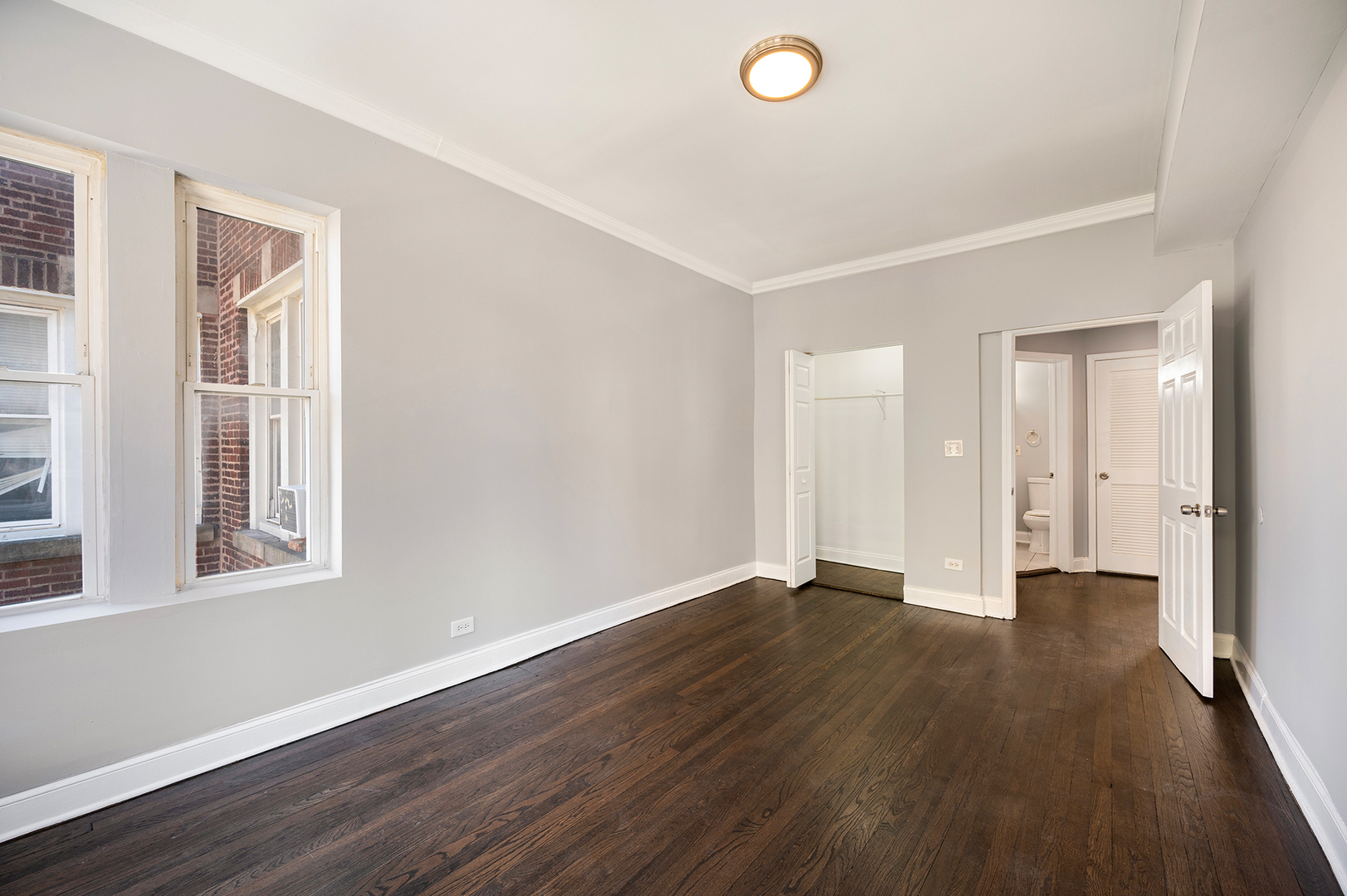 2437 East 74th Street, Unit 3W Chicago, IL 60649 - Photo 16 of 18 a view of an empty room with wooden floor and a window