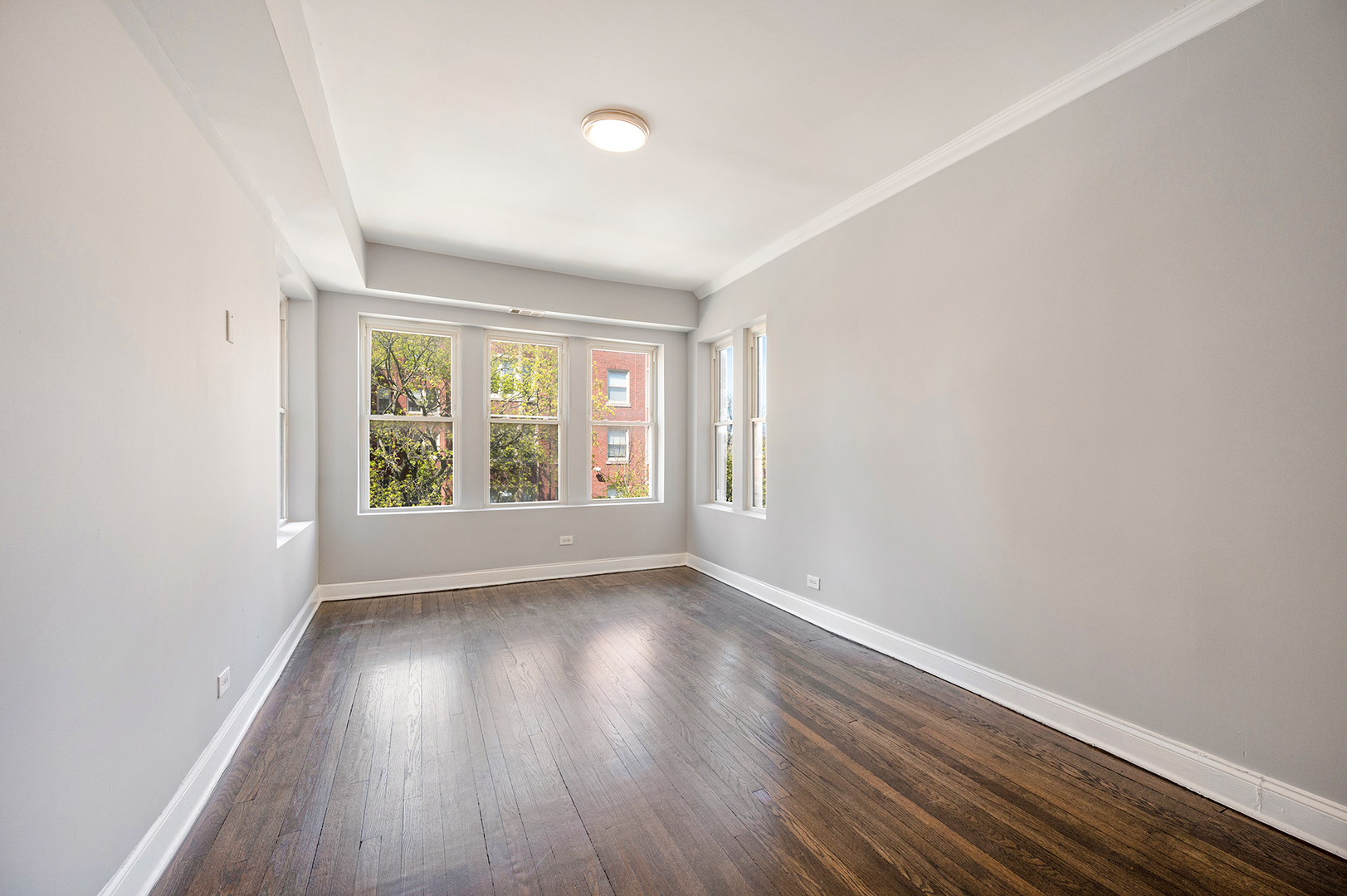 2437 East 74th Street, Unit 3W Chicago, IL 60649 - Photo 17 of 18 an empty room with wooden floor and windows