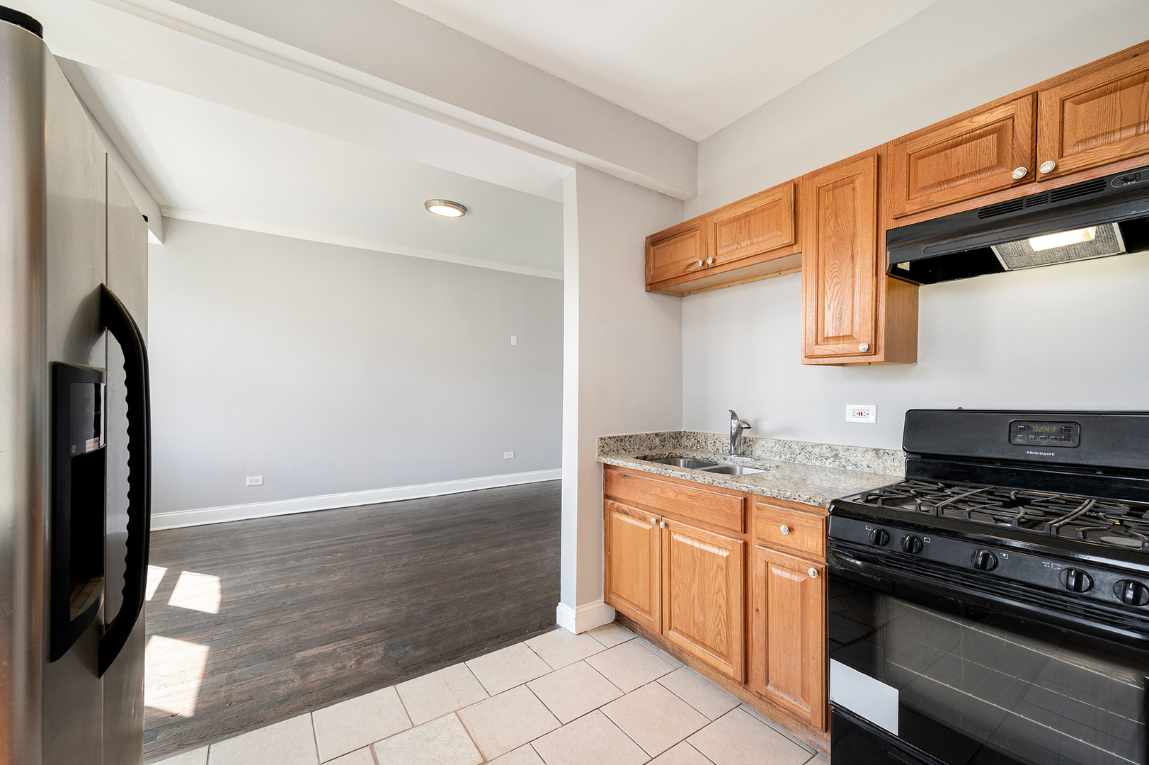 2437 East 74th Street, Unit 3W Chicago, IL 60649 - Photo 5 of 18 a kitchen with stainless steel appliances granite countertop a stove and a refrigerator