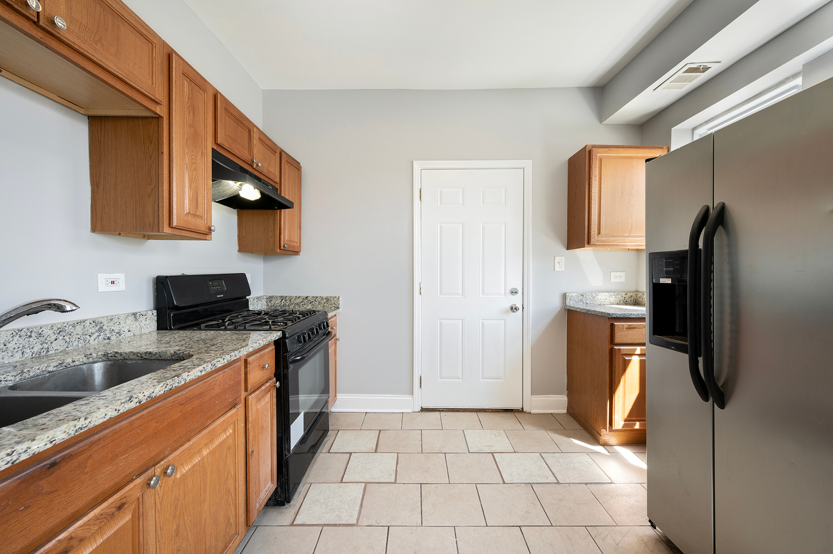 2437 East 74th Street, Unit 3W Chicago, IL 60649 - Photo 6 of 18 a kitchen with stainless steel appliances granite countertop a refrigerator stove and sink