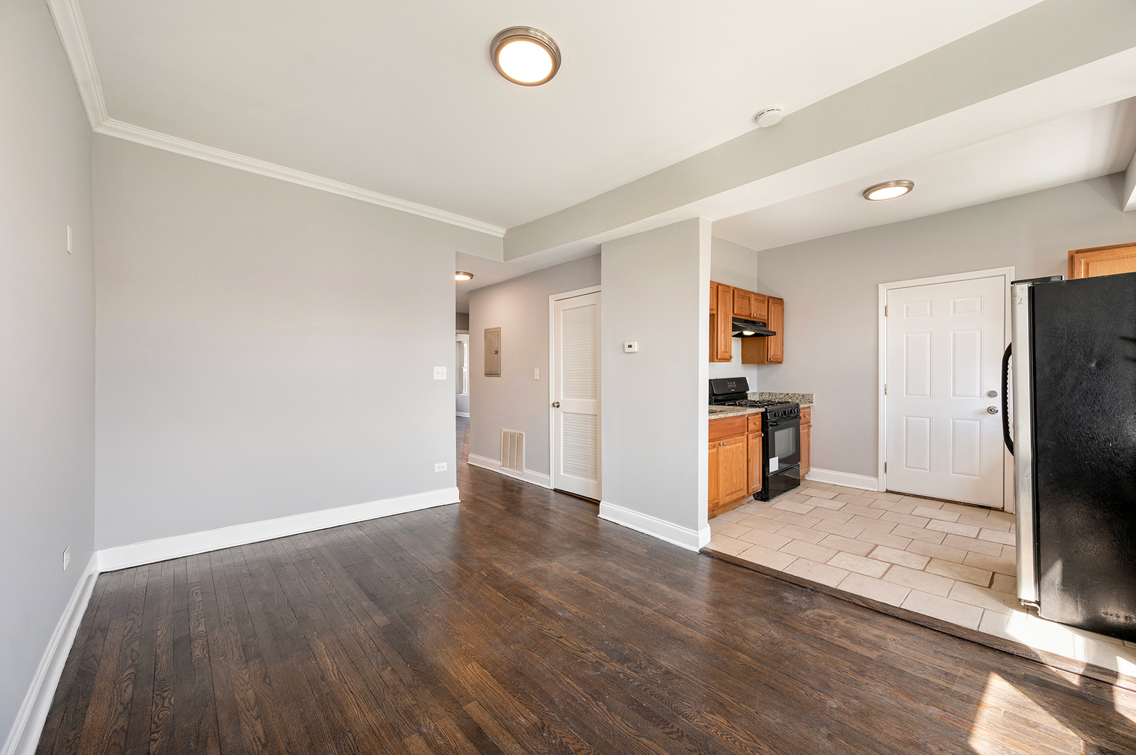 2437 East 74th Street, Unit 3W Chicago, IL 60649 - Photo 7 of 18 a view of a kitchen with refrigerator stove and wooden floor