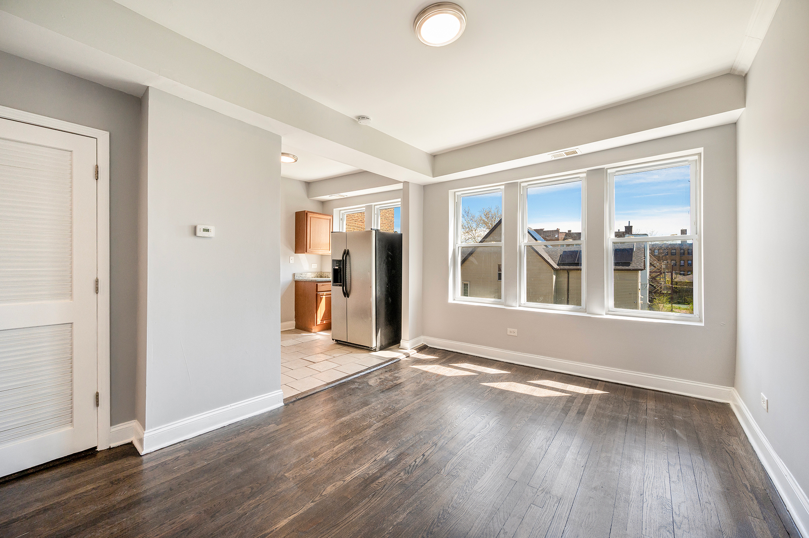 2437 East 74th Street, Unit 3W Chicago, IL 60649 - Photo 8 of 18 an empty room with wooden floor and windows