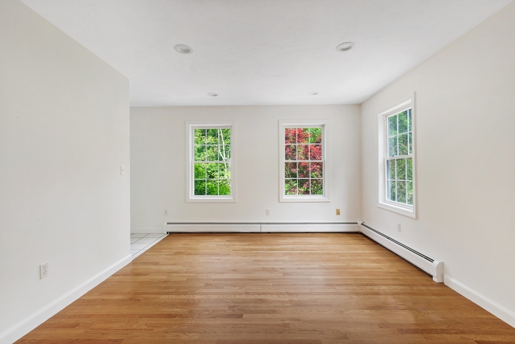 341 Quaddick Road Thompson, CT 06277 - Photo 8 of 29 an empty room with wooden floor and windows