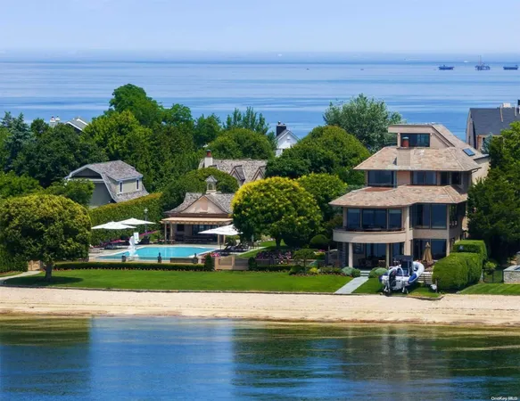 a front view of a house with a garden and lake view