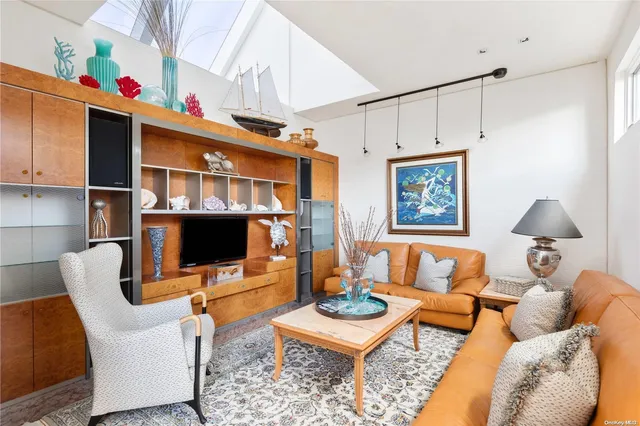 a living room with furniture a rug and a flat screen tv