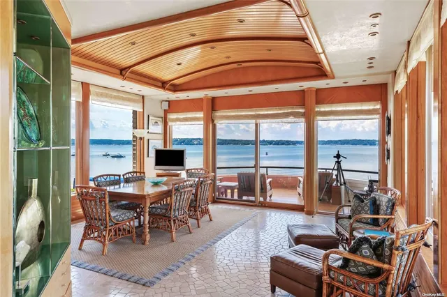 a dining room with furniture water view and a large window