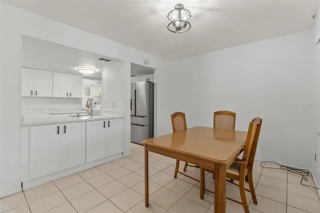a kitchen with a refrigerator a table and chairs in it