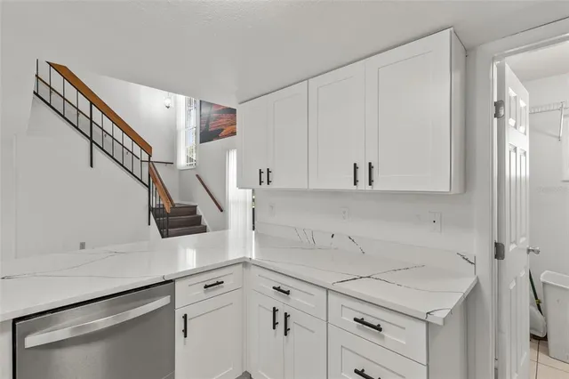 a kitchen with white cabinets and white appliances