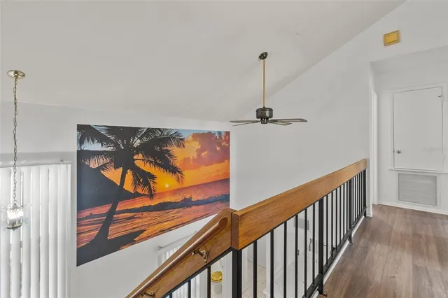 a view of a hallway with wooden floor and stairs