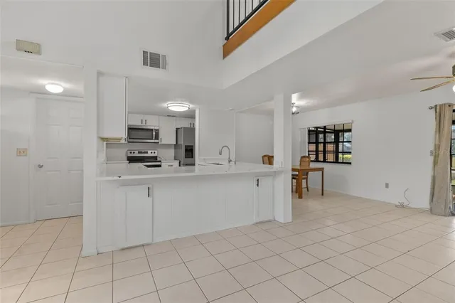 a kitchen with white cabinets and appliances