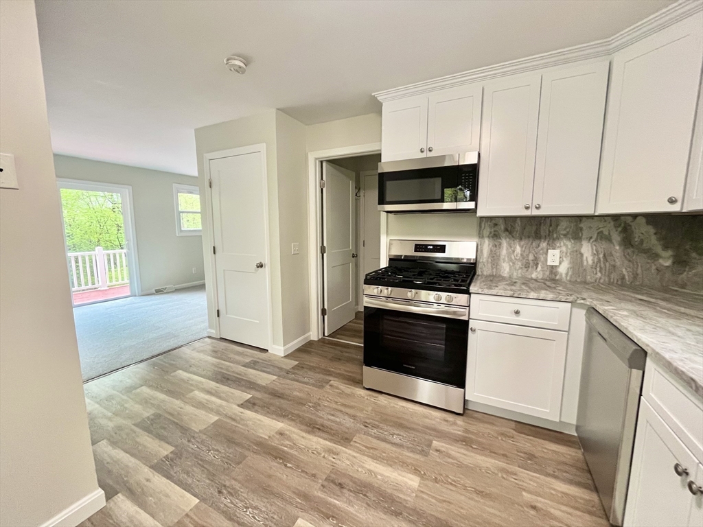 196 Munn Road Monson, MA 01057 - Photo 3 of 16 a kitchen with granite countertop a stove a sink and a refrigerator