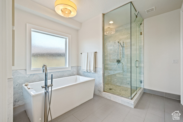 6026 Zen Trail Way St. George, UT 84790 - Photo 13 of 41 Full bathroom featuring a freestanding bath, a stall shower, tile patterned floors, wainscoting, and tile walls