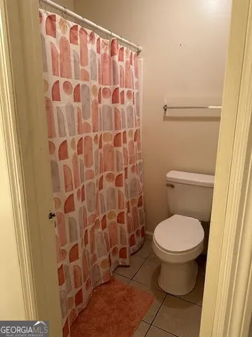 a bathroom with a toilet and a shower curtain