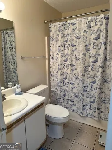 a bathroom with a granite countertop toilet and a sink