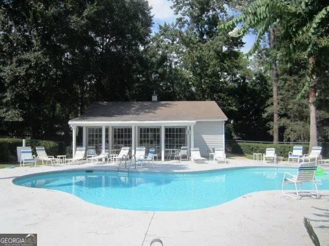 a view of house with a yard potted plants and large tree