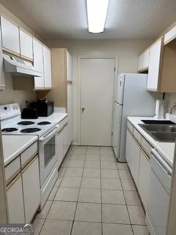 a kitchen with a sink a stove and refrigerator
