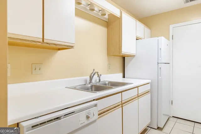 a bathroom with a sink and a refrigerator