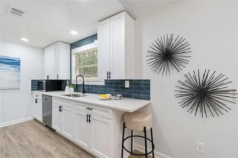 a kitchen with a sink a counter and cabinets