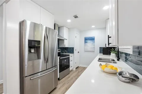 a kitchen with stainless steel appliances granite countertop a refrigerator and a stove