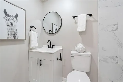 a bathroom with a toilet sink and mirror