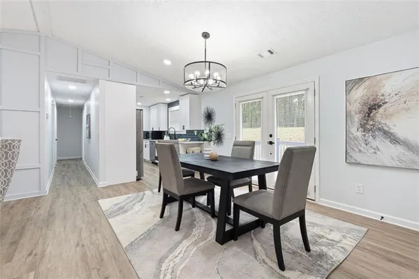 a view of a dining room with furniture wooden floor and a chandelier